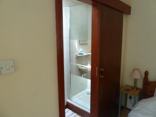 a bathroom with a shower with a tub and a sink at Hillside Self Catering in Salisbury