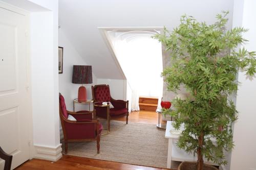a living room with red chairs and a plant at Botanic Views Guest House in Lisbon