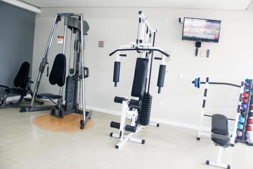 a gym with several tread machines and a flat screen tv at Hotel City Hall in São José dos Campos