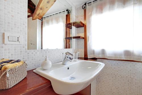 a bathroom with a white sink and a mirror at Fenix Do Dogi Apartments in Venice