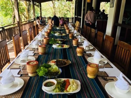 a long table with plates of food on it at Tadlo Lodge in Ban Nongtoung