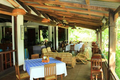 a restaurant with tables and chairs on a deck at Tadlo Lodge in Ban Nongtoung