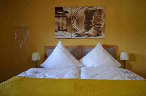 a bed with white sheets and a picture of boots at Fewo Calico in Eging