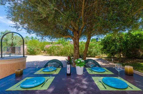 a table with blue plates and a bottle of wine at Hort de Can Bou in Porreres