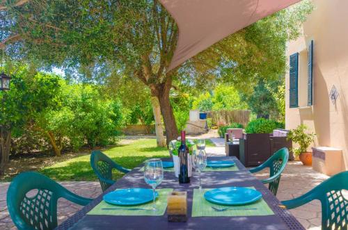 a table with plates and wine glasses on a patio at Hort de Can Bou in Porreres