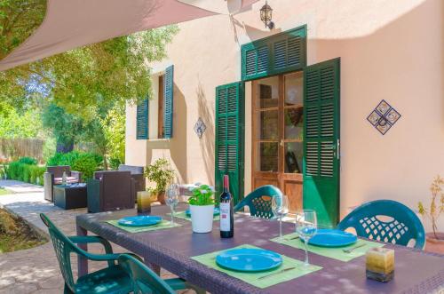 a table with green chairs and a table with wine glasses at Hort de Can Bou in Porreres