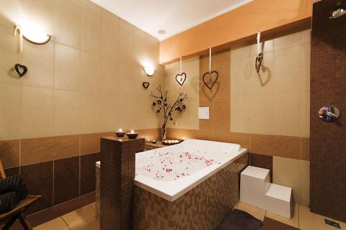 a bathroom with a bath tub with hearts on the wall at Hotel Kudowa Manufaktura Relaksu in Kudowa-Zdrój