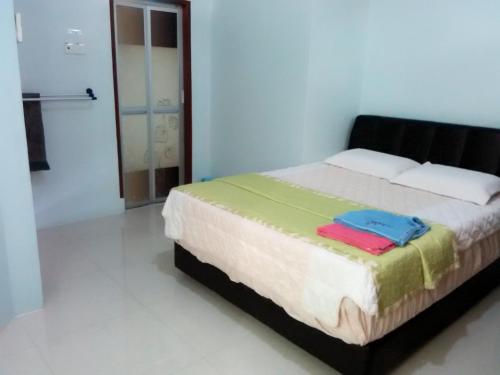 un dormitorio con una cama en una habitación en Penginapan MyCJ - Roomstay, en Kuala Terengganu