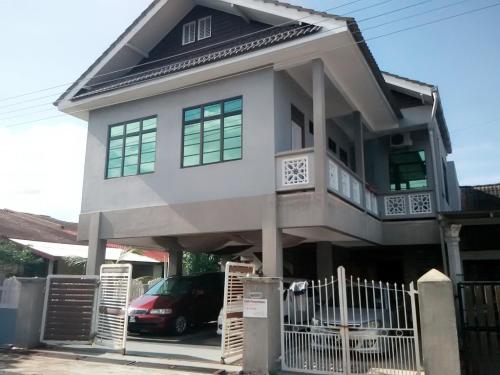 a house with a car parked in front of it at Penginapan MyCJ - Roomstay in Kuala Terengganu