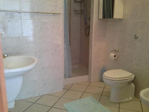 W łazience znajduje się toaleta, umywalka i prysznic. w obiekcie Appartamento Elegante E Panoramico Con Splendida Vista Mare w mieście Buggerru