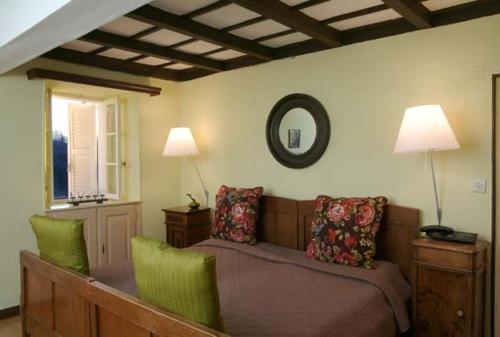 a bedroom with a bed with two chairs and a mirror at Albergo della Posta in Astano