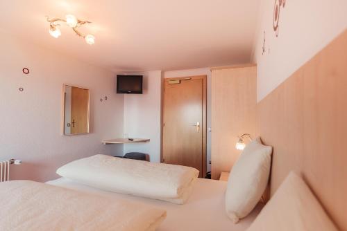 a hotel room with two beds and a television at Pension Wiesenrain in Maranza
