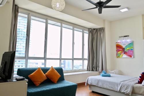 a bedroom with a blue couch and a large window at Parkview KLCC Serviced Suites in Kuala Lumpur