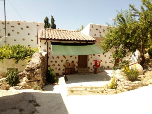 a house with a green umbrella in front of it at CASA RURAL "LOS CASARES" in Nerpio