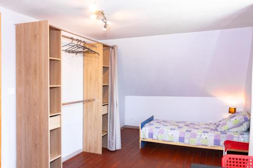 een slaapkamer met een bed en een boekenplank bij Maison de village Salency in Salency