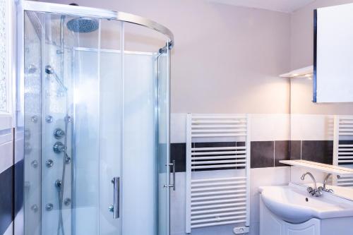 een badkamer met een douche en een wastafel bij Maison de village Salency in Salency