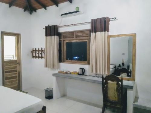 a room with a counter and a window and a mirror at Mansala Safari House in Udawalawe