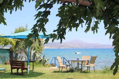 a table and chairs in front of the water at Maria's Apartments in Kalyves