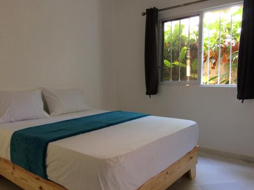 een bed in een kamer met een raam bij Caoba in Las Terrenas