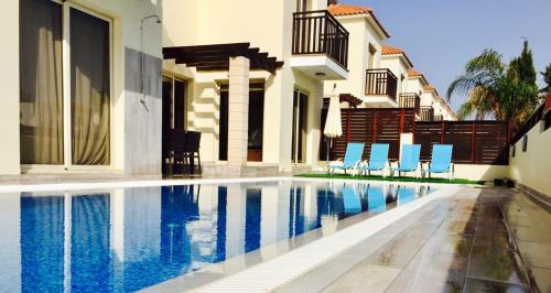 a swimming pool in front of a house at Menelaos Villa 9 in Paralimni