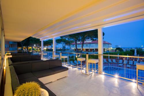 a patio with a couch and chairs on a balcony at Hotel Garden Sea Wellness & Spa 4 stelle superior in Caorle