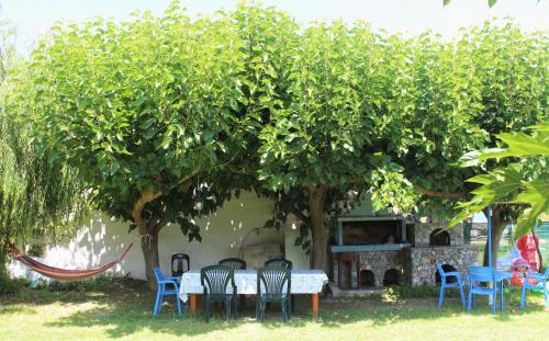 a table and chairs under a tree in a yard at Maria's Apartments in Kalyves