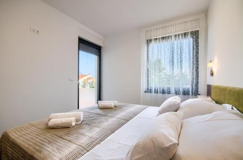 a bedroom with a large bed with two pillows on it at Rooms K&T sea side luxury in Pula