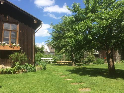 a yard next to a barn with a tree at Landhaus Bruckner in Bad Alexandersbad