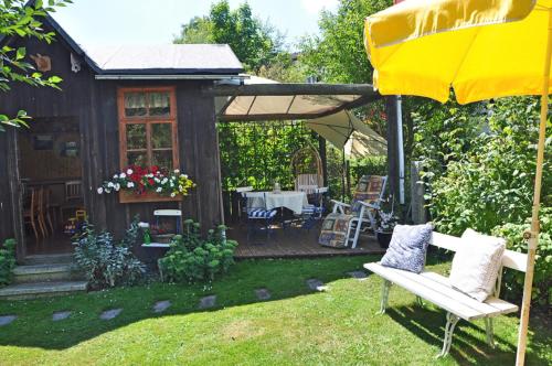 a garden with a bench and an umbrella at Landhaus Bruckner in Bad Alexandersbad