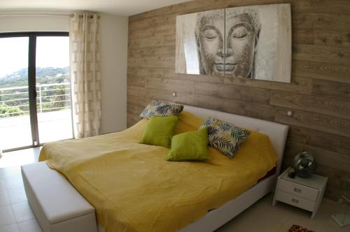une chambre avec un lit avec des draps et des oreillers jaunes dans l'établissement Villa Happiness Sainte-Maxime, à Sainte-Maxime