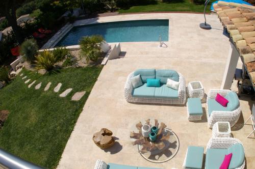 Elle offre une vue sur la terrasse dotée d'une piscine et de chaises longues. dans l'établissement Villa Happiness Sainte-Maxime, à Sainte-Maxime