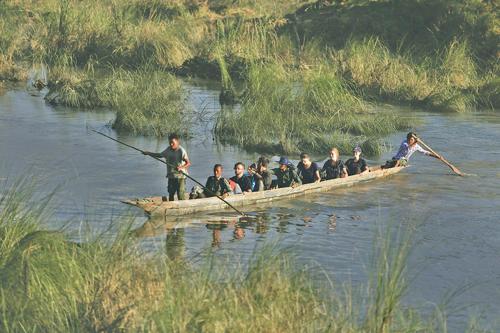 a group of people in a boat on a river at Hotel Shiva's Dream in Sauraha