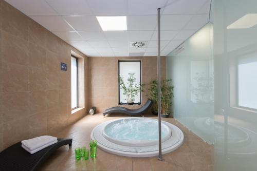 uma casa de banho com uma grande banheira num quarto em Hotel Panská Zahrada em Dobřichovice