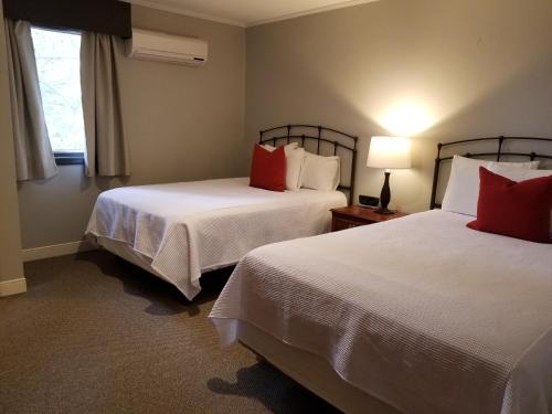 a hotel room with two beds with red pillows at Cedar Creek in New Haven