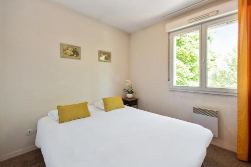 a bedroom with a white bed and a window at Appart'City Classic Dijon - Toison D'Or in Dijon