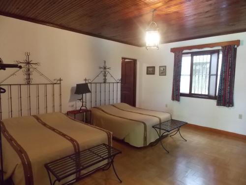a room with two beds and a window at Hotel Casa Duranta in Cobán