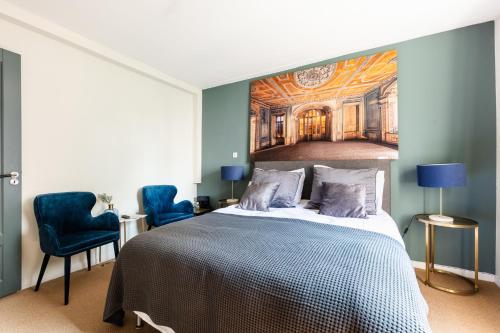 a bedroom with a bed with a painting on the wall at Canal Wow Suites Amsterdam in Amsterdam