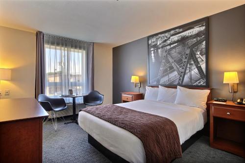 a hotel room with a bed and a desk at Super 8 by Wyndham Trois-Rivieres in Trois-Rivières