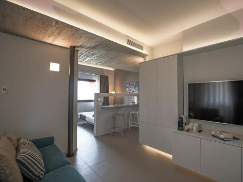 a living room with a blue couch and a television at Serre Alte Landscape Luxury Rooms in Matelica