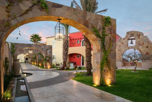an archway leading to a building with palm trees at The Residences at Hacienda Encantada in Cabo San Lucas