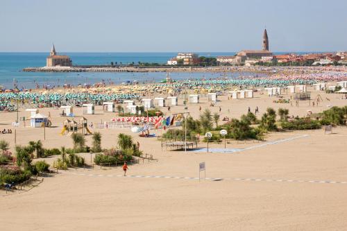 a beach with a lot of people and the ocean at Hotel Garden Sea Wellness & Spa 4 stelle superior in Caorle