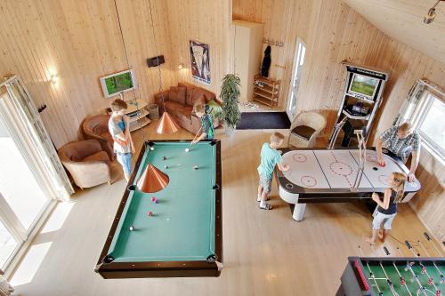 a group of children playing in a room with a pool table at Luksus-poolhus B5 in Harboør