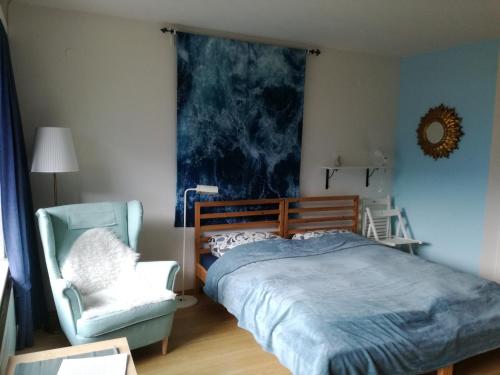 a bedroom with a bed and a chair at Haus am Sonnweg in Maurach