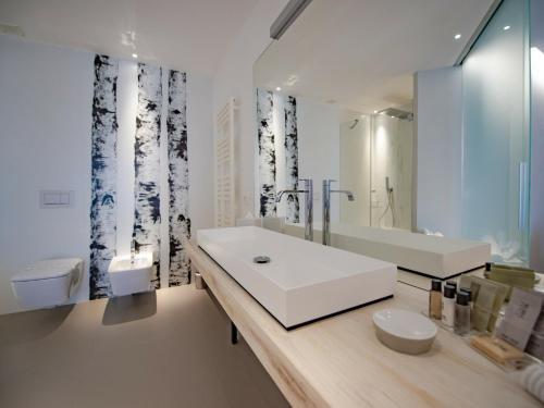 a bathroom with a white sink and a mirror at Serre Alte Landscape Luxury Rooms in Matelica