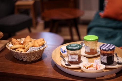 a table topped with a basket of bread and dips at 5 Chambres en Ville in Clermont-Ferrand