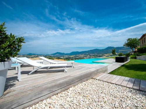 a patio with chairs and a swimming pool at Serre Alte Landscape Luxury Rooms in Matelica