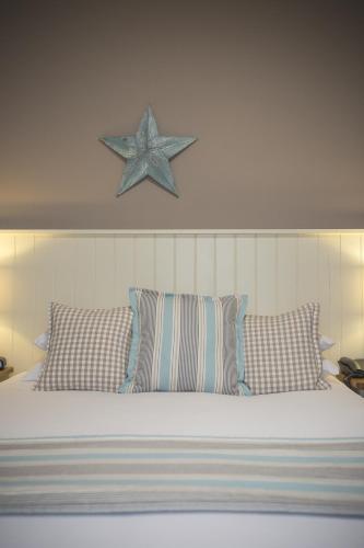 a bed with striped pillows and a starfish above it at George Hotel, BW Signature Collection in Norwich