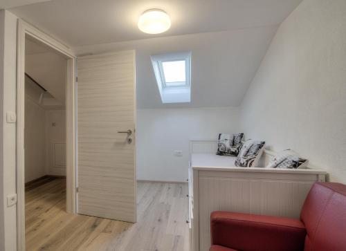 a living room with a red chair and a window at BC Eleven - mit Zentralheizung in Senj
