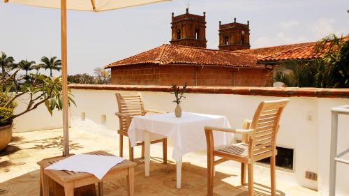 a table and chairs on a patio with an umbrella at Casa Oniri Hotel Boutique in Barichara