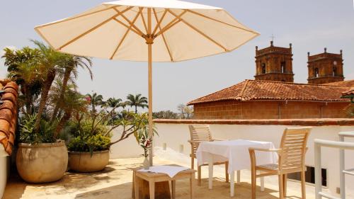 a table and chairs with an umbrella on a patio at Casa Oniri Hotel Boutique in Barichara